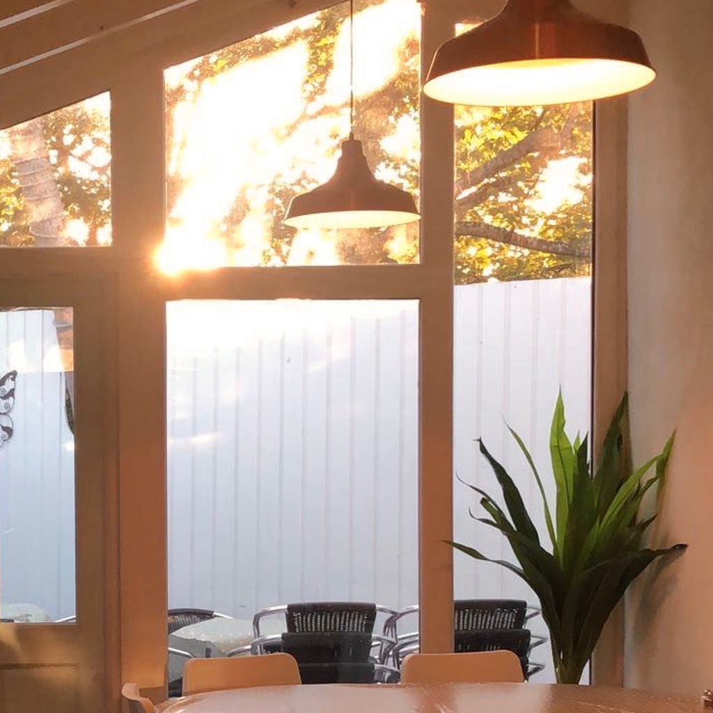 Copper pendant lights and a potted plant in the glass-roofed conservatory